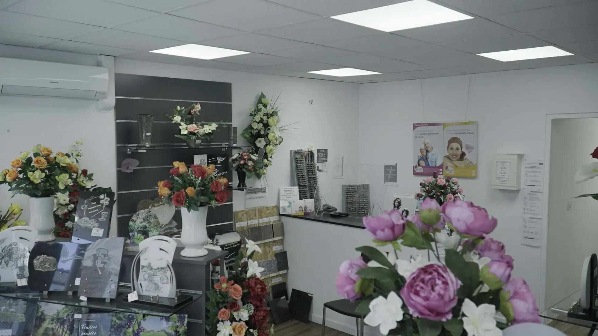 Comptoir d'accueil d'une agence de pompes funèbres décoré de fleurs fraîches