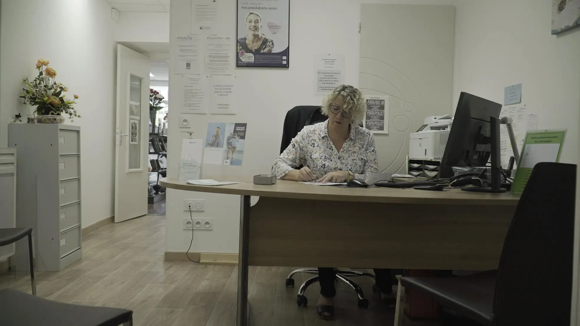 Conseillère funéraire installée à son bureau pour l'accueil et le conseil des familles