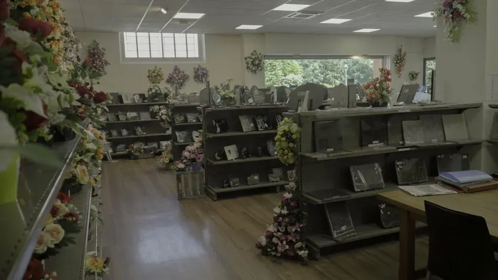 Espace de vente d'articles funéraires avec plaques commémoratives et compositions florales
